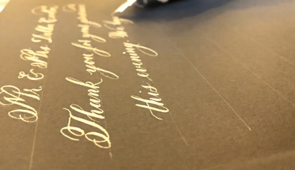 Gold ink handwritten thank you note inside custom book, example of live wedding thank you note personalization in Houston.