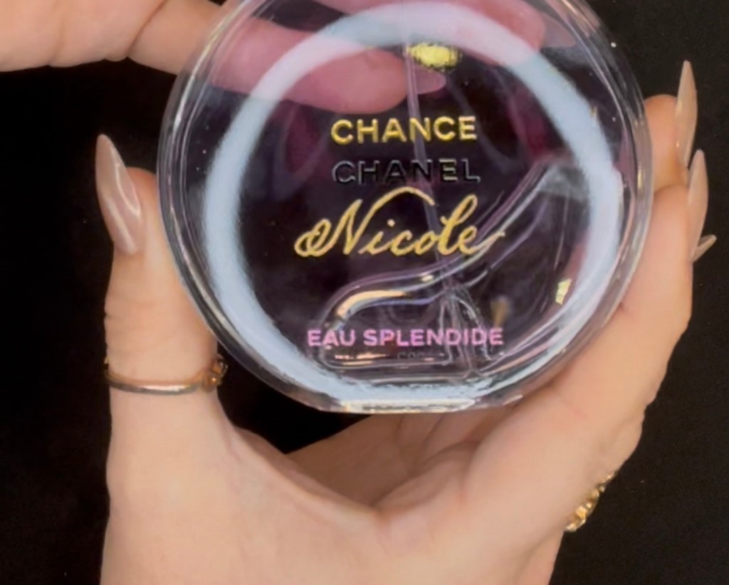 Jessica Wofford holding a purple Chanel Chance perfume bottle engraved with the name “Nicole” and finished with shimmering gold inlay. Created live at Nordstrom’s All-In engraving event at the Houston Galleria, showcasing luxury perfume customization and hand engraving by Houston calligrapher and engraver Jessica Wofford.