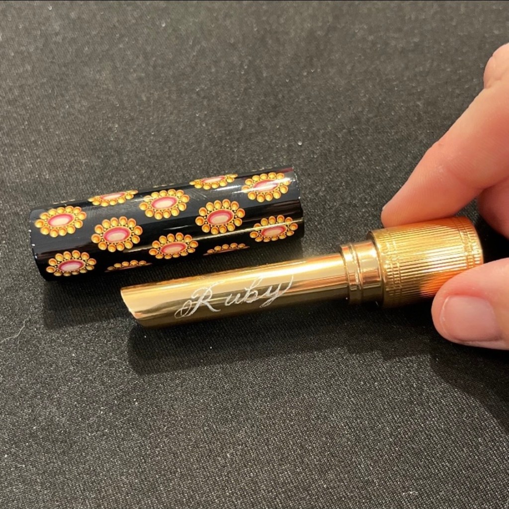 Gucci Rouge à Lèvres gold lipstick tube engraved with the name Ruby during a live luxury personalization event
