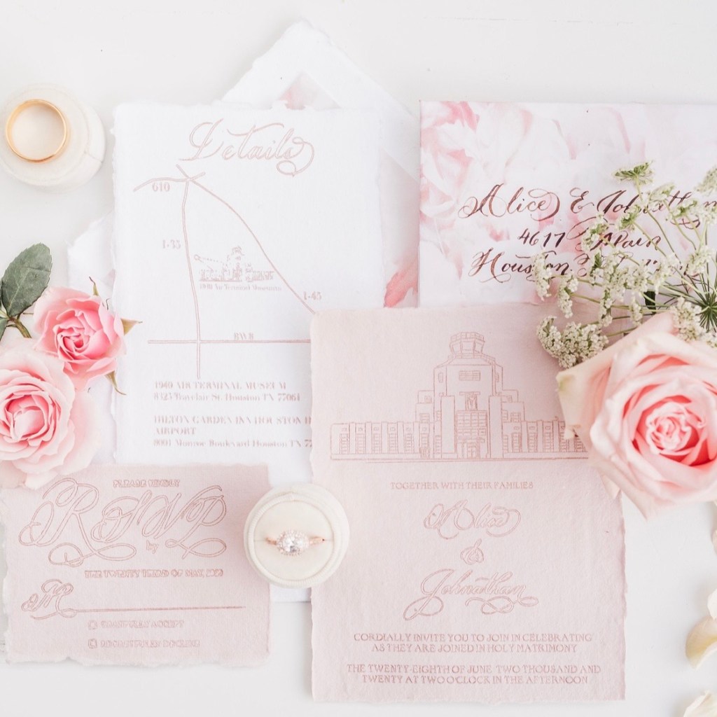 Handmade blush wedding invitation suite with gold foil calligraphy and an illustrated 1940s Air Terminal Museum design by Wofford Calligraphy, styled with roses and cotton paper details.