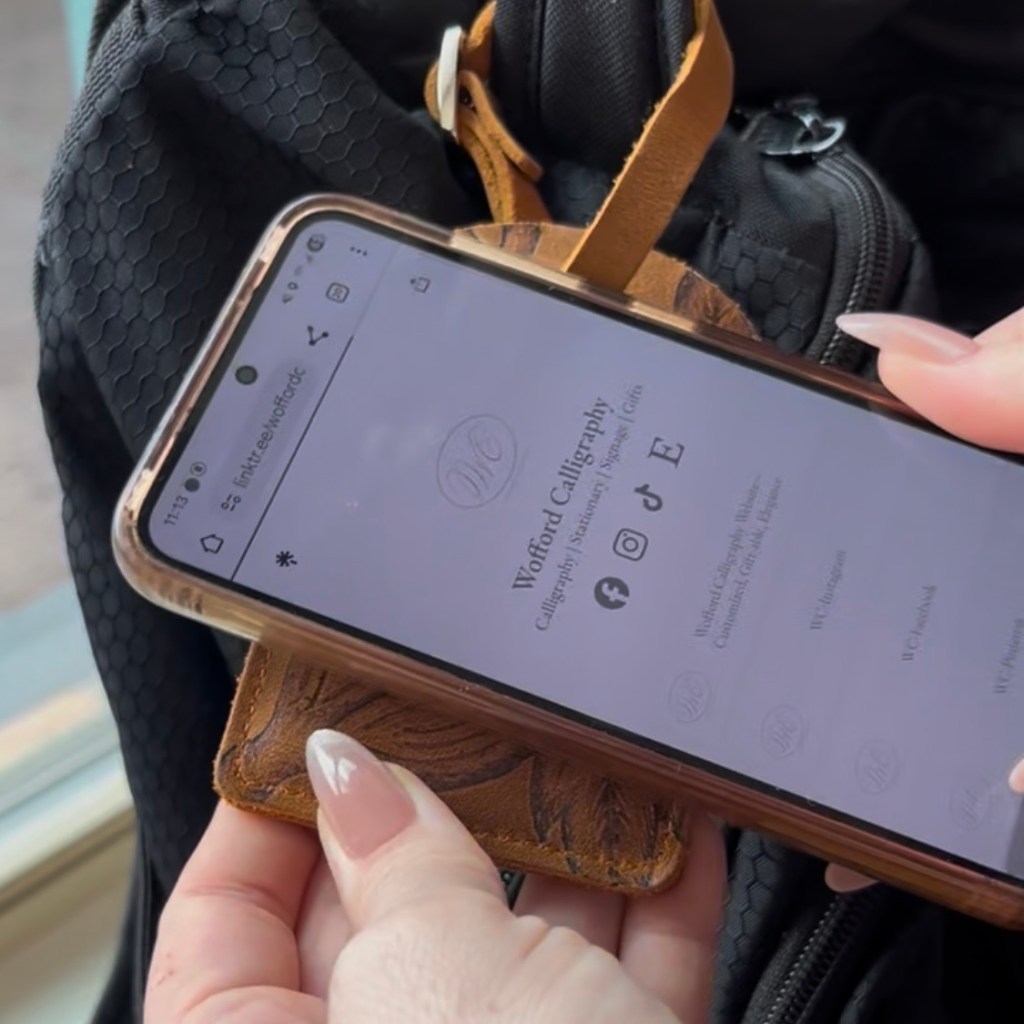 phone tapping custom leather NFC business card holder to open Linktree page