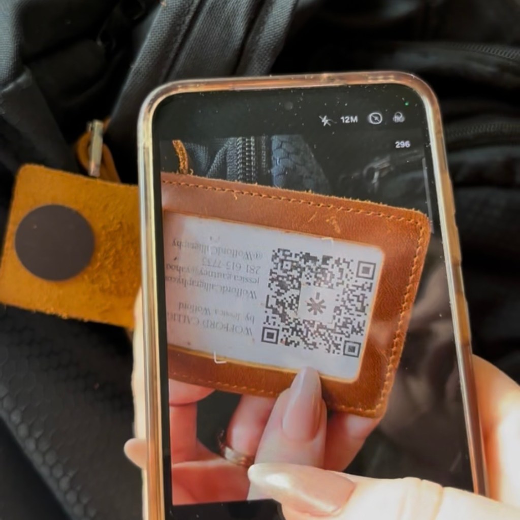 phone scanning QR code through window of custom leather NFC business card holder