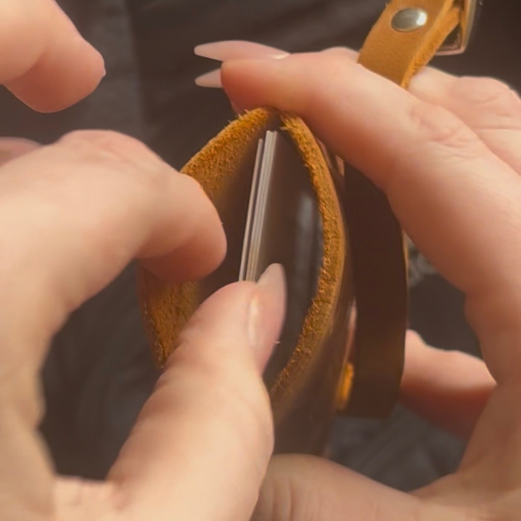 hands removing physical business cards from a custom leather NFC business card holder