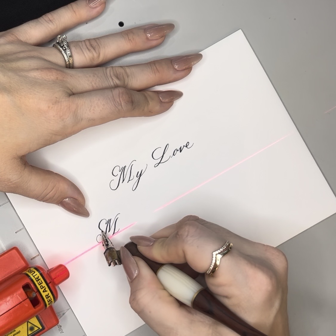 Close-up of a calligrapher writing a love letter in dip pen calligraphy during a Dior event
