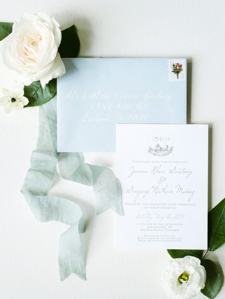 Custom wedding invitation suite with calligraphy names and soft blue envelope showing personalized wedding typography.