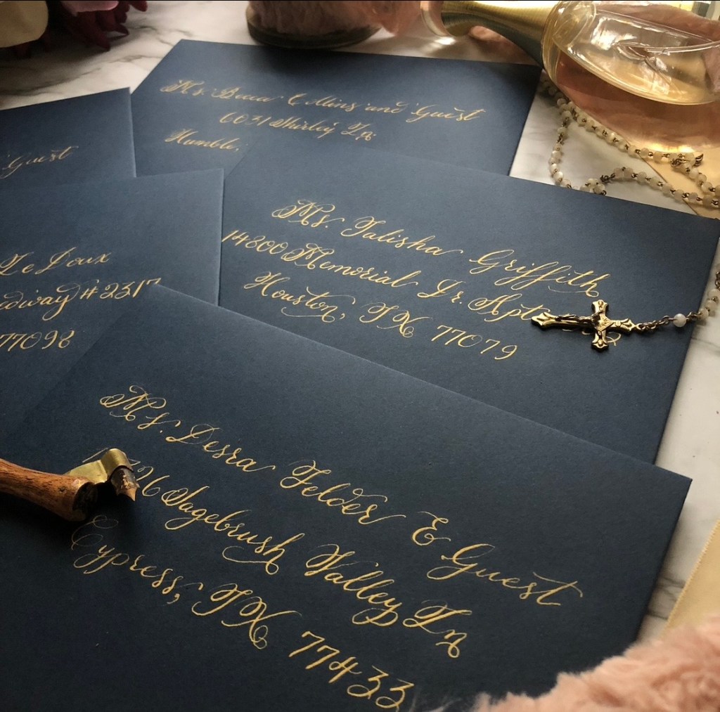 Graduation announcement envelopes with gold calligraphy addressing on navy blue envelopes