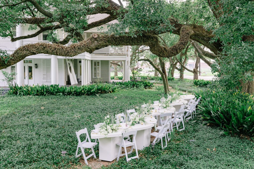Outdoor wedding reception table under large oak tree at Houston venue, designed for intimate, intentional guest experience.
