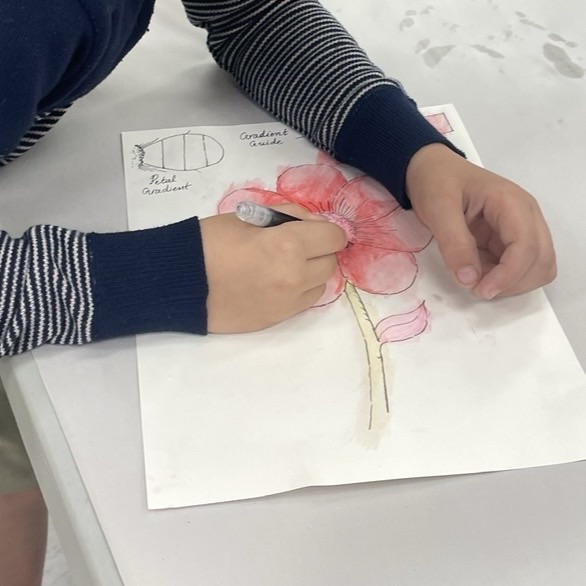 Child working on watercolor flower art in class, learning that perfect is not art
