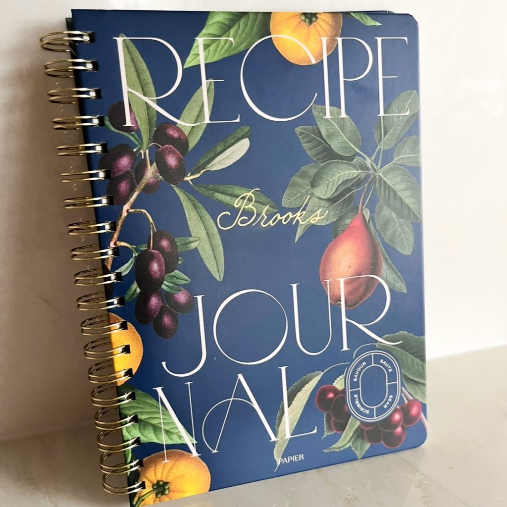 Personalized recipe notebook with handwritten family name in gold calligraphy on navy cover