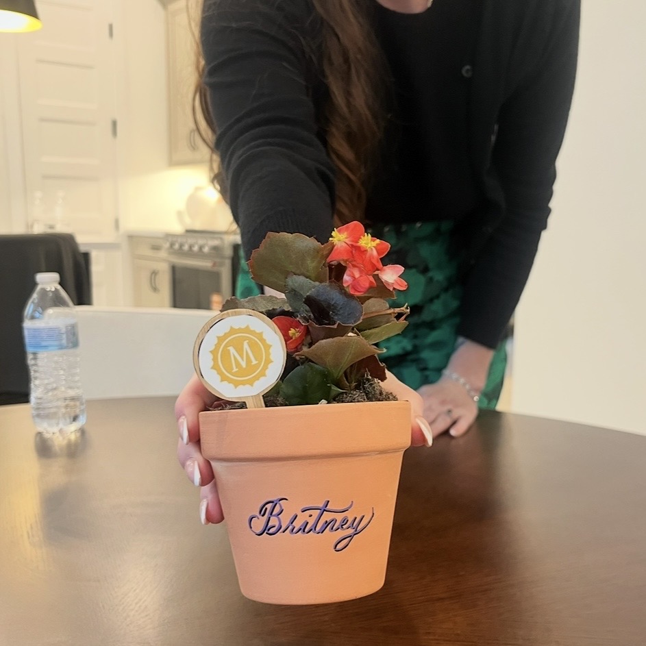 Personalized terra cotta pot with name Britney in purple calligraphy with black shadow at Houston live event