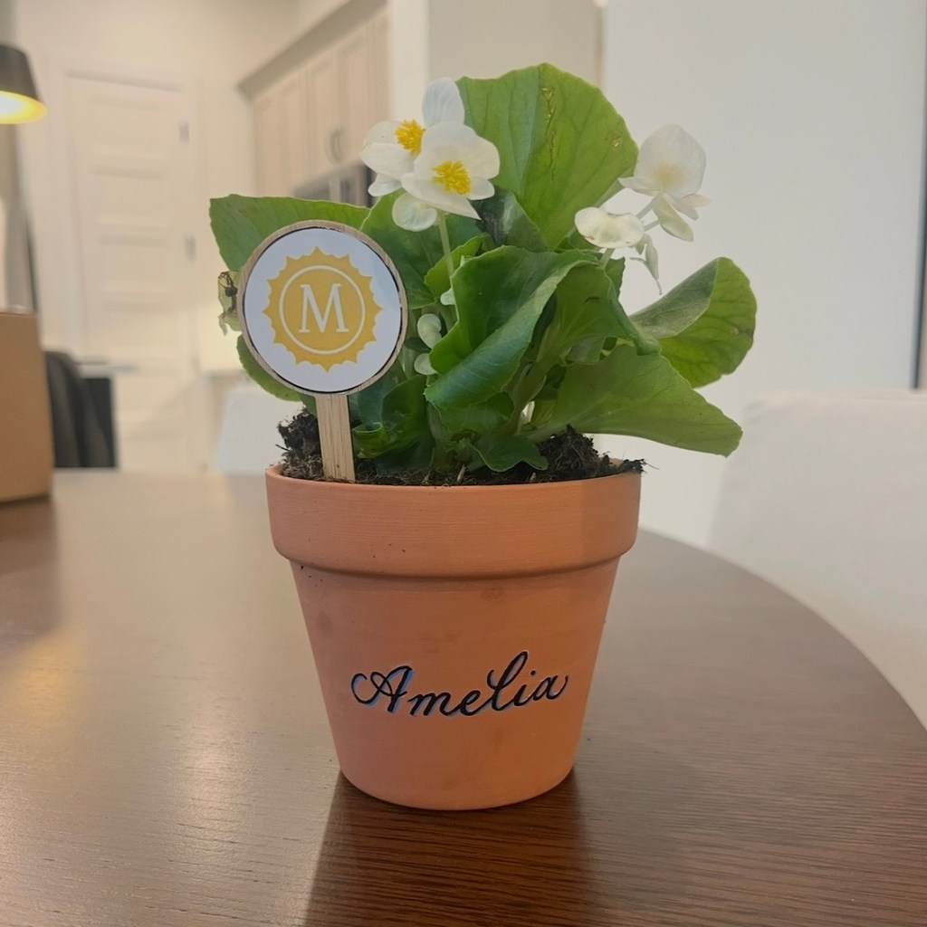 Personalized terra cotta pot with name Amelia in black calligraphy with blue shadow at Houston live event