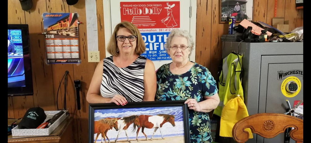 My grandmother handing one of her horse paintings to its new owner in her living room.
