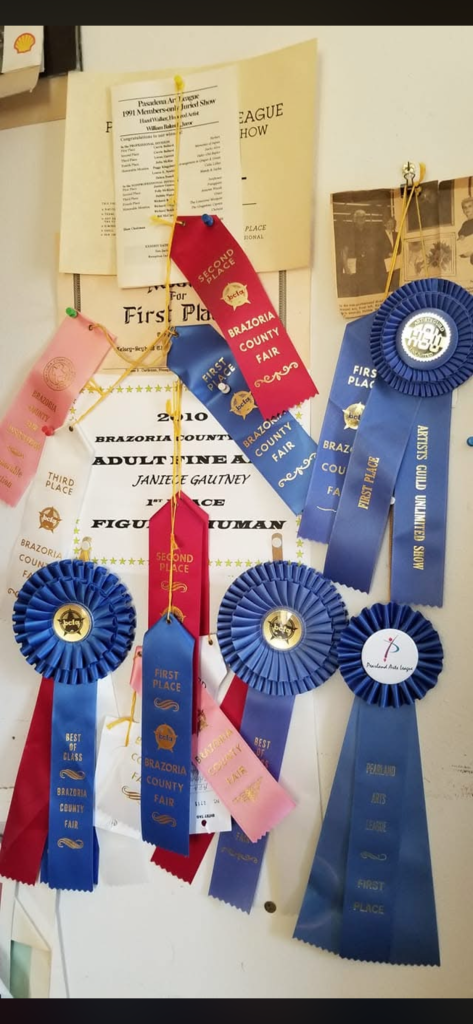 Wall covered with art show ribbons earned over decades of painting and creative work.
