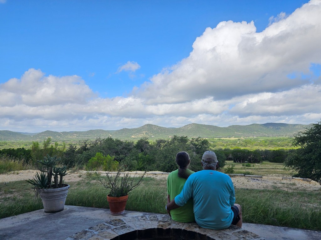 Parents sitting together overlooking the Texas Hill Country near Garner State Park during a family trip celebrating a 70th birthday.
