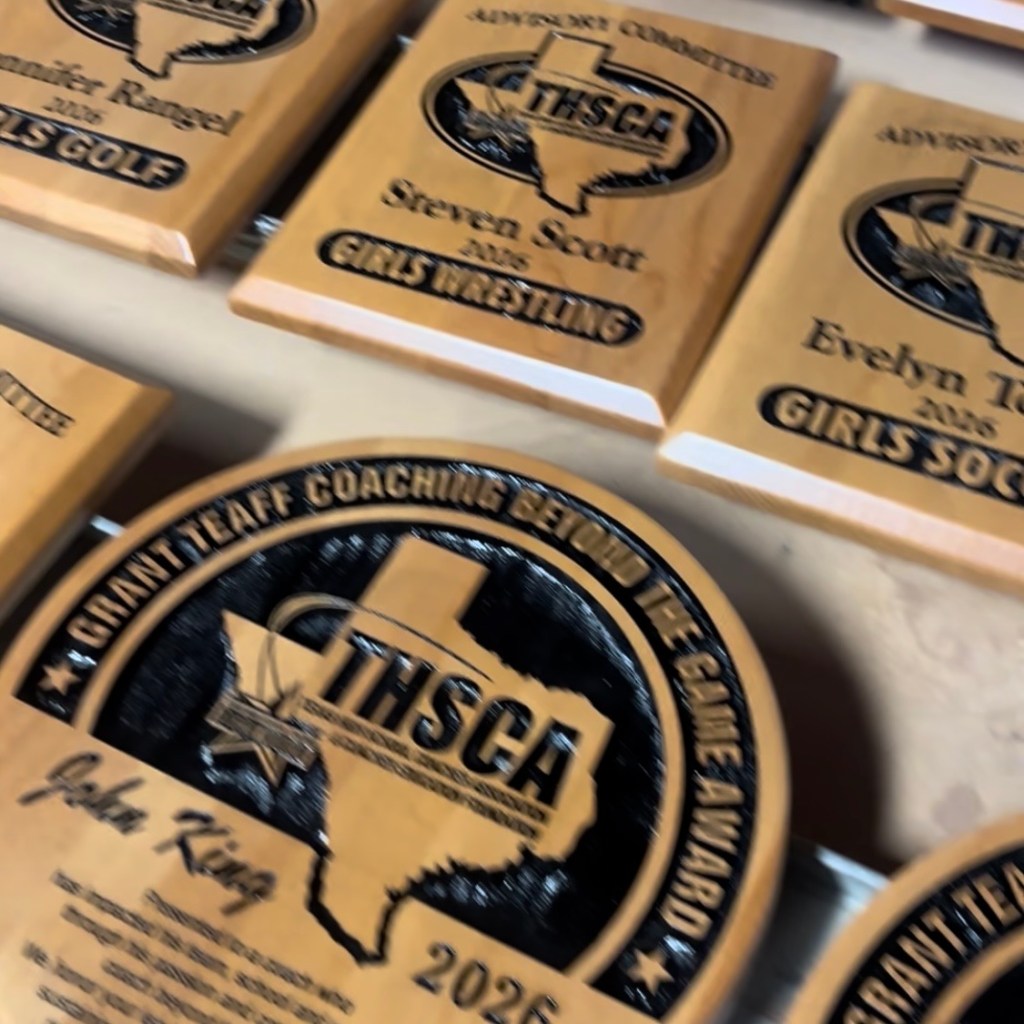 Custom sandblasted wood plaques drying in a workshop, showing professional finishing techniques used for long-lasting custom awards and signage.