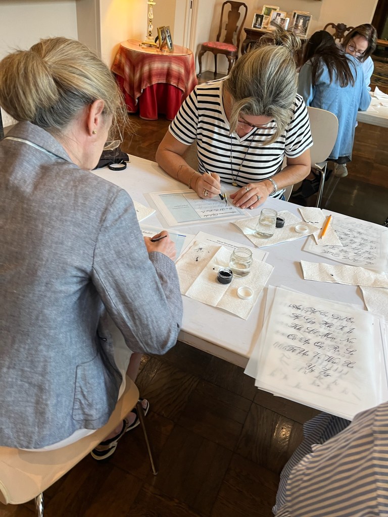 Students practicing pointed pen calligraphy during a hands-on workshop taught at the Rienzi Museum of Fine Arts, preserving traditional lettering skills through in-person instruction.