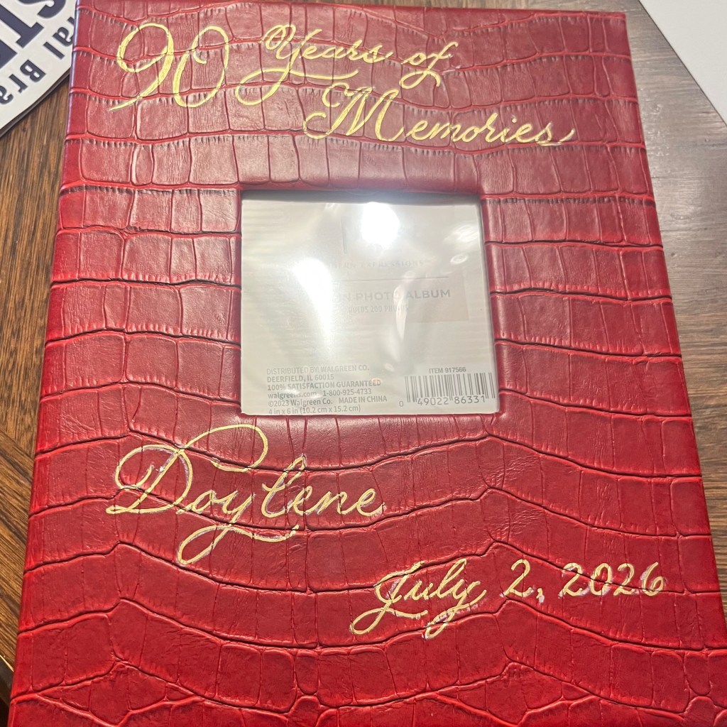 Red personalized photo album with gold hand-lettered calligraphy reading "90 Years of Memories," created as a custom 90th birthday gift.