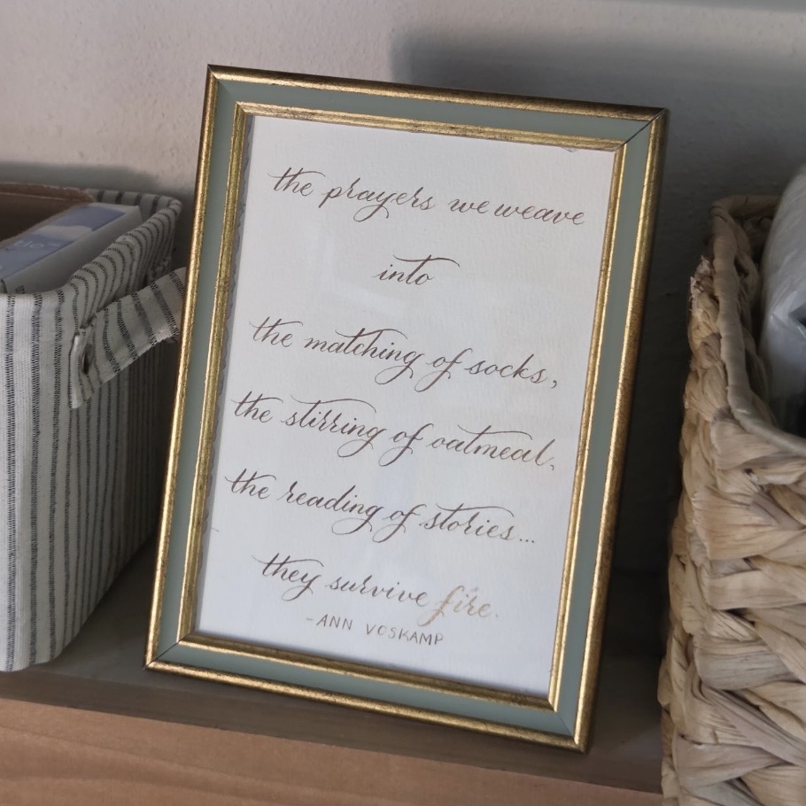 Framed dip pen calligraphy print with a meaningful family quote, shown as personalized artwork for a new home.