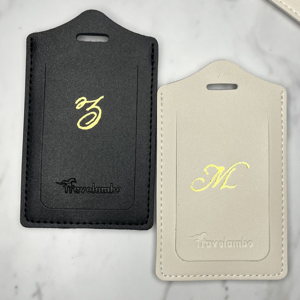 Black and white vegan leather luggage tags personalized with gold foil initials as an example of custom client gifts for realtors.